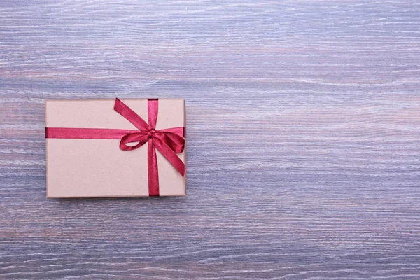 Geschenkbox mit Schleife auf Holz Hintergrund — Stockfoto
