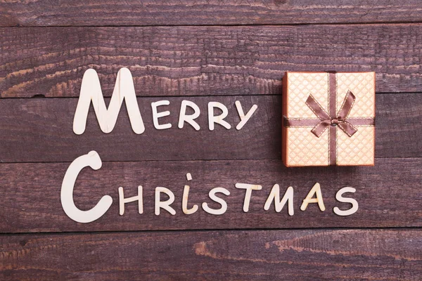 Feliz Navidad texto y decoraciones sobre un fondo de madera — Foto de Stock