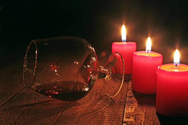 Glas Brandy oder Cognac und Kerze auf dem Holztisch — Stockfoto
