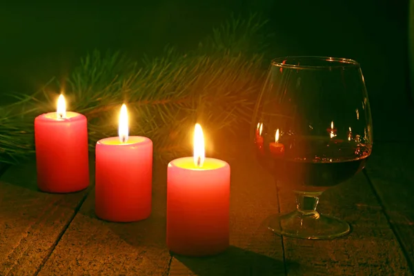 Brandy glass and candles on black background — Stock Photo, Image