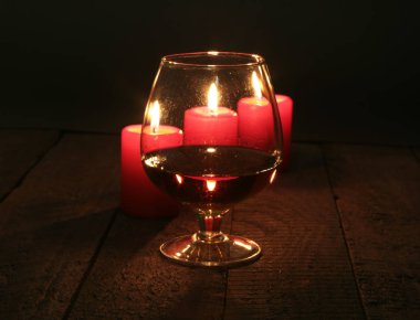 Brendi cam ve siyah arka plan üzerine mumlar