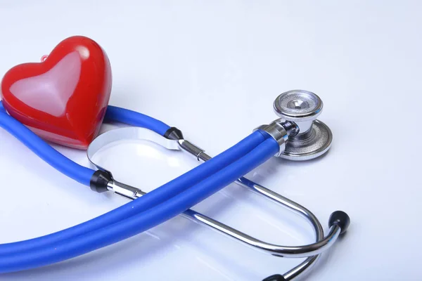 Cardiograma com estetoscópio e coração vermelho na mesa, close-up — Fotografia de Stock