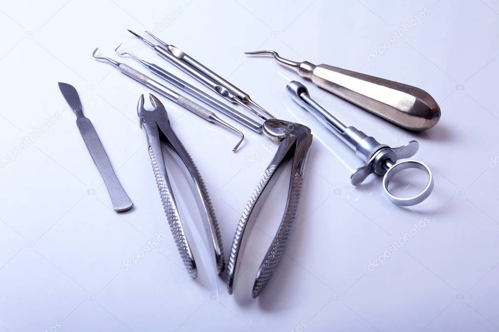 surgical instruments and tools including scalpels, forceps tweezers arranged on a table for surgery