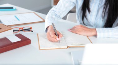 Masada oturan ve bir kağıt yazma iş kadınları