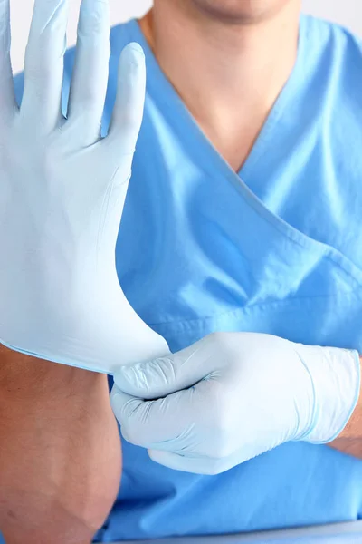 Arzt zieht sterile Handschuhe isoliert weiß an — Stockfoto