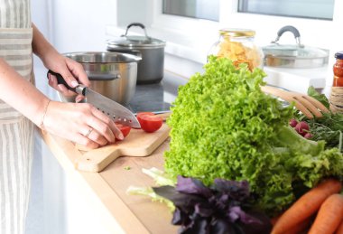 Kesme tahtası üzerinde taze sebze tencerede pişirme kavramı düşüyor