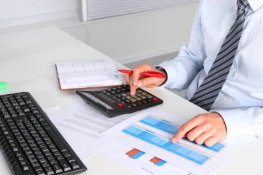 Masada oturan ve bir kağıt yazma iş adamı