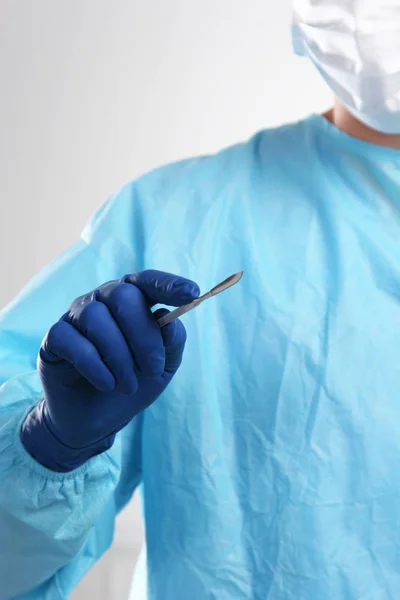 Un chirurgien tient un scalpel dans une salle d'opération — Photo