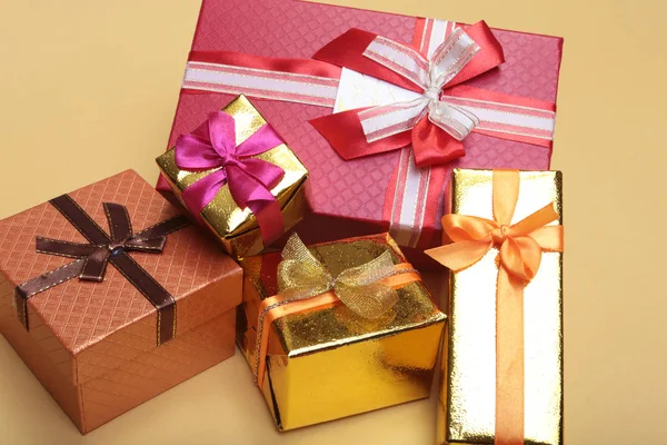 Belle boîte cadeau en or avec arc rouge et rubans sur fond — Photo