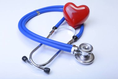 Kırmızı kalp ve beyaz arka planda steteskop.