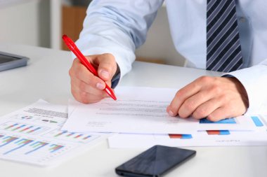 Masada oturan ve bir kağıt yazma iş adamı