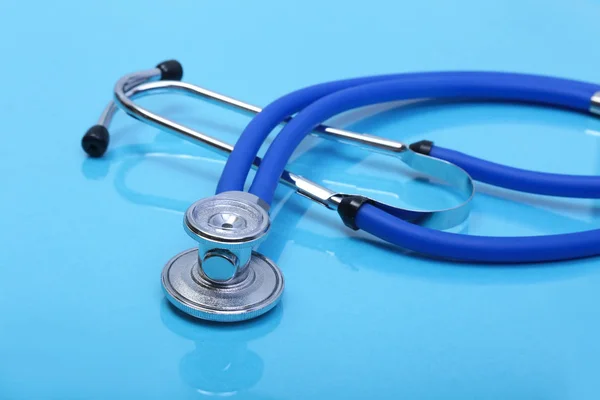 Stethoskop und medizinisches Gerät auf blauem Hintergrund — Stockfoto
