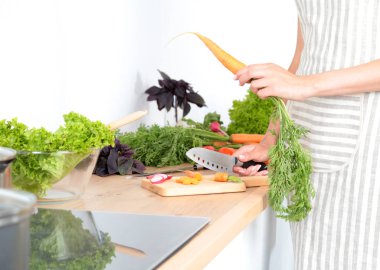 Kesme tahtası üzerinde taze sebze tencerede pişirme kavramı düşüyor