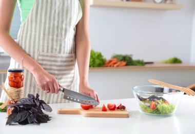 Kesme tahtası üzerinde taze sebze tencerede pişirme kavramı düşüyor