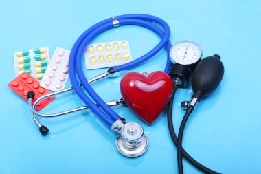 Kırmızı kalp ve beyaz arka planda steteskop.