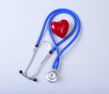 Kırmızı kalp ve beyaz arka planda steteskop.