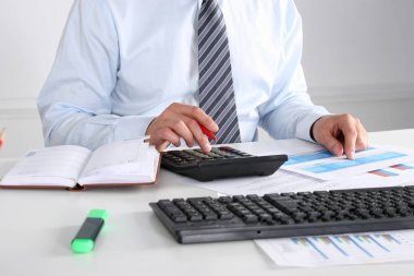 Laptop ile masada oturan ve ofiste germe neşeli genç işadamı