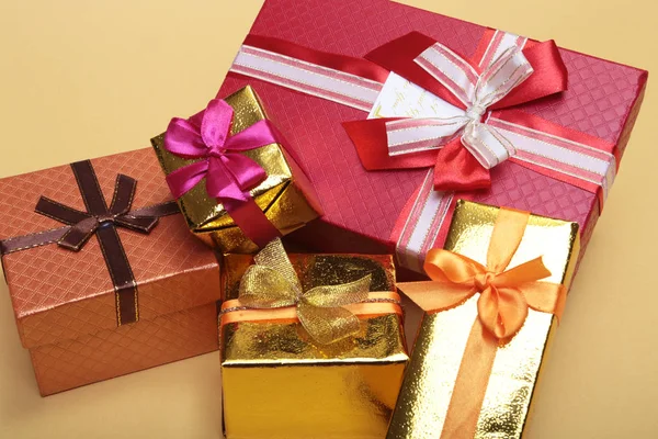 Beautiful gold present box with red bow and ribbons on backgound