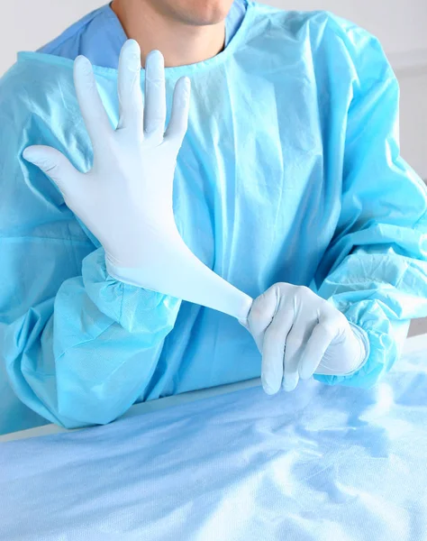 Доктор надевает стерильные перчатки изолированные белые — стоковое фото