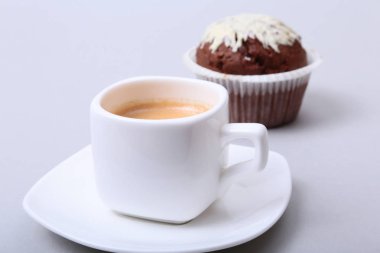 Çip muffin ve beyaz arka plan üzerinde kahve çekirdekleri ile klasik tarzı espresso vurdu.