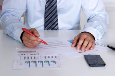 Laptop ile masada oturan ve ofiste germe neşeli genç işadamı