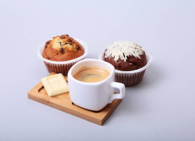 Çip muffin ve beyaz arka plan üzerinde kahve çekirdekleri ile klasik tarzı espresso vurdu.