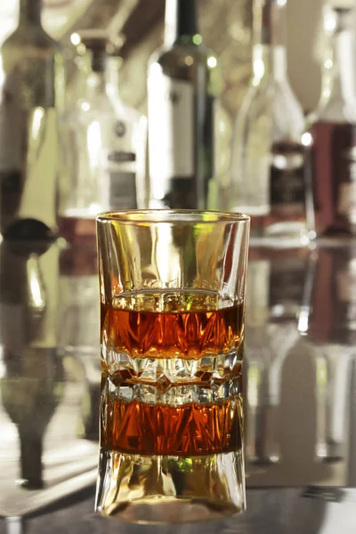 Bir bardak konyak, brandy veya ayna masada whiscy. arka planda bir bar şişelerde — Stok fotoğraf