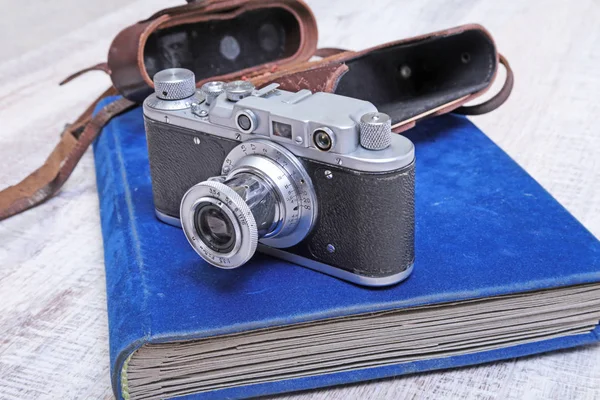 Vintage old film photo-camera in leather case and album — Stock Photo, Image