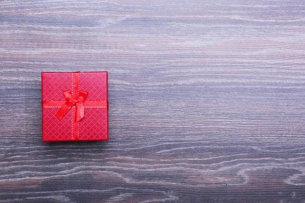 Beautiful gold present box with red bow and ribbons on backgound