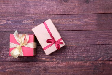 ahşap arka plan üzerinde kırmızı ve altın hediye kutusu.