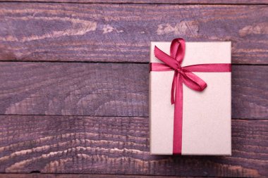 ahşap arka plan üzerinde kırmızı ve altın hediye kutusu.