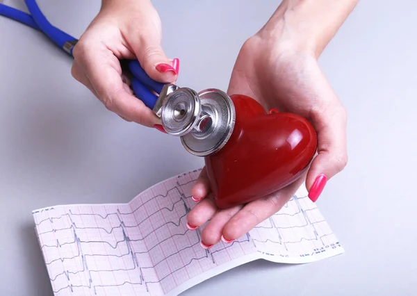 Női orvos tart kezében piros játék szív és sztetoszkóp. Cardio terapeutát, ritmuszavar koncepció — Stock Fotó