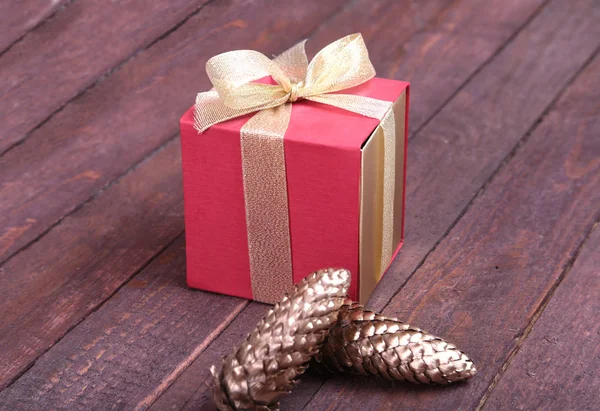 Scatola regalo rosso e oro su sfondo legno . — Foto Stock