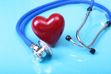 Sağlık stetoskop ve mavi ayna arka plan üzerinde izole kırmızı kalp