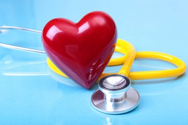 Sağlık stetoskop ve mavi ayna arka plan üzerinde izole kırmızı kalp