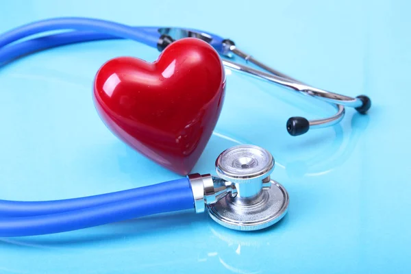 Ιατρικό στηθοσκόπιο και κόκκινη καρδιά που απομονώνονται σε φόντο μπλε καθρέφτη — Φωτογραφία Αρχείου