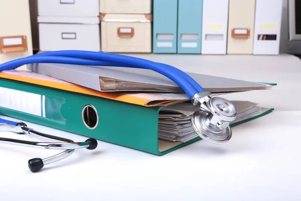 Folder file, stethoscope and note on the desk. blurred background.