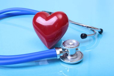 Sağlık stetoskop ve mavi ayna arka plan üzerinde izole kırmızı kalp. metninizi yerleştirebilirsiniz.