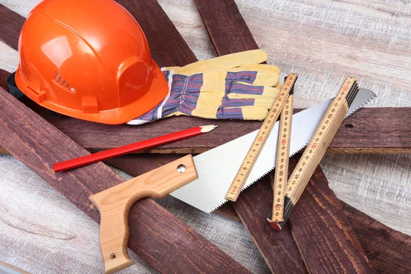 Sombrero duro naranja, gafas de seguridad, guantes y cinta métrica sobre fondo de madera. usted puede colocar su texto — Foto de Stock