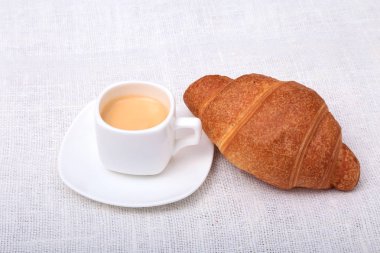 Çıtır taze kruvasanlar ve fincan kahve espresso bir beyaz arka plan, sabah kahvaltı, seçici odak