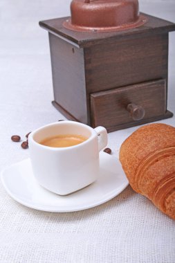 Çıtır taze kruvasanlar, fincan kahve espresso ve kahve değirmeni bir beyaz arka plan, sabah kahvaltı, seçici odak