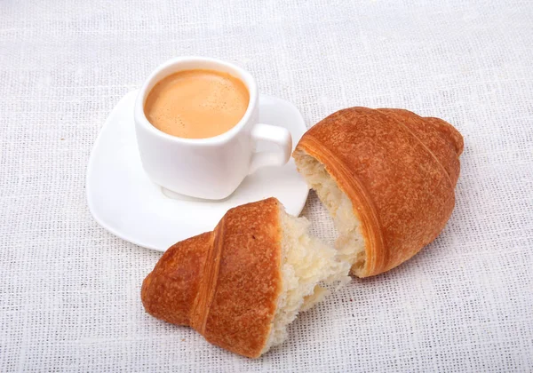 Τραγανά φρέσκα κρουασάν και καφέ εσπρέσο σε ένα λευκό φόντο, πρωινό, επιλεκτική εστίαση — Φωτογραφία Αρχείου