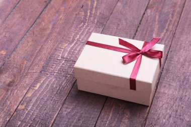 ahşap arka plan üzerinde kırmızı ve altın hediye kutusu.