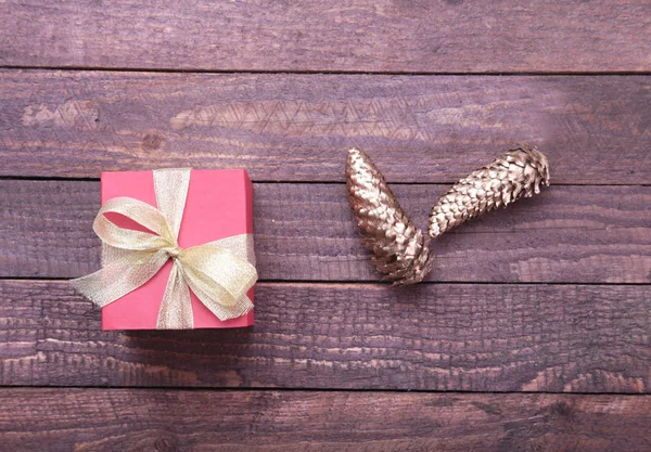 Caja de regalo roja y dorada sobre fondo de madera . — Foto de Stock