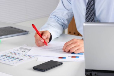 Laptop ile masada oturan ve ofiste germe neşeli genç işadamı