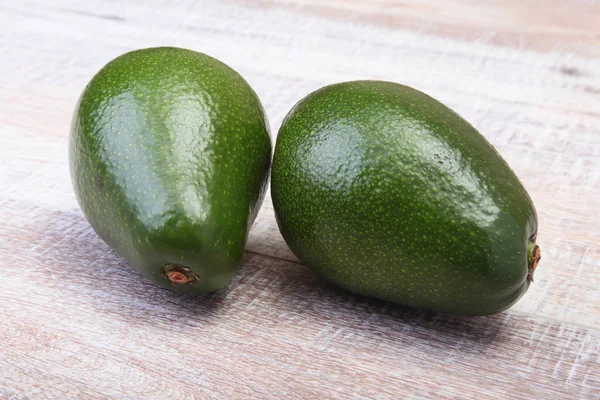 Verse, groene Avocado geïsoleerd op houten achtergrond. — Stockfoto