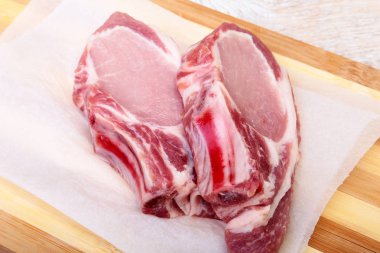 Çiğ domuz pirzolası, kesme tahtası üzerinde baharat. Hazır yemek pişirmek için.