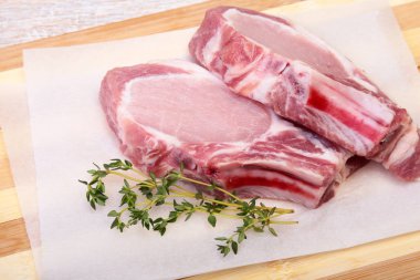 Çiğ domuz eti, baharat ve biberiye kesme tahtası üzerinde. Hazır yemek pişirmek için.