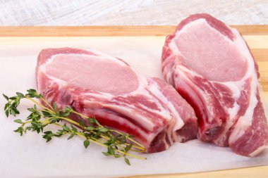 Çiğ domuz eti, baharat ve biberiye kesme tahtası üzerinde. Hazır yemek pişirmek için.