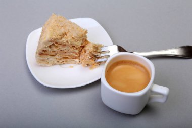 Ev yapımı Napoleon puf pasta plaka ve geleneksel espresso kahve beyaz arka plan üzerinde izole. yakın çekim.